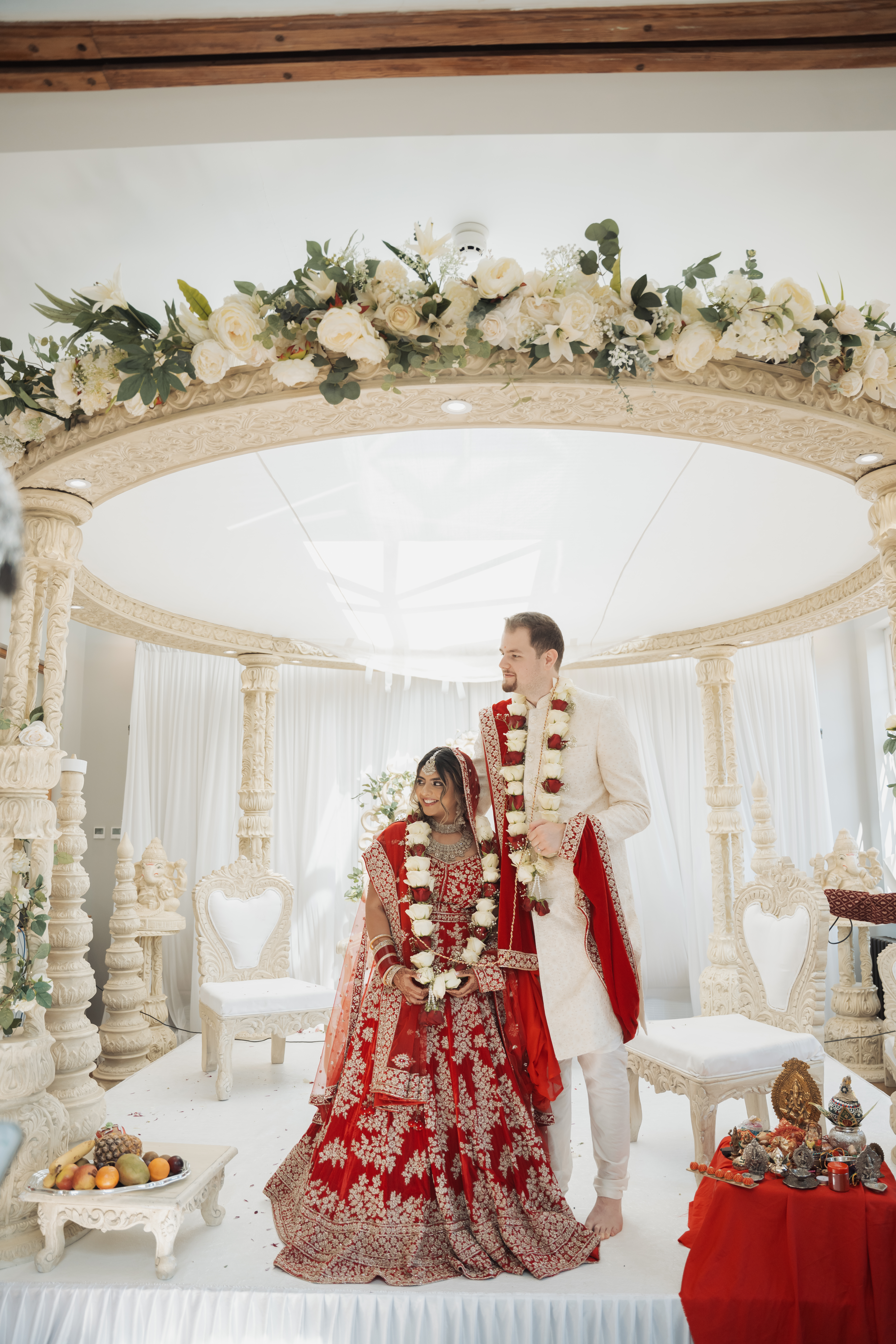 Elegant Muslim Nikah ceremony under a white floral arch at a countryside venue